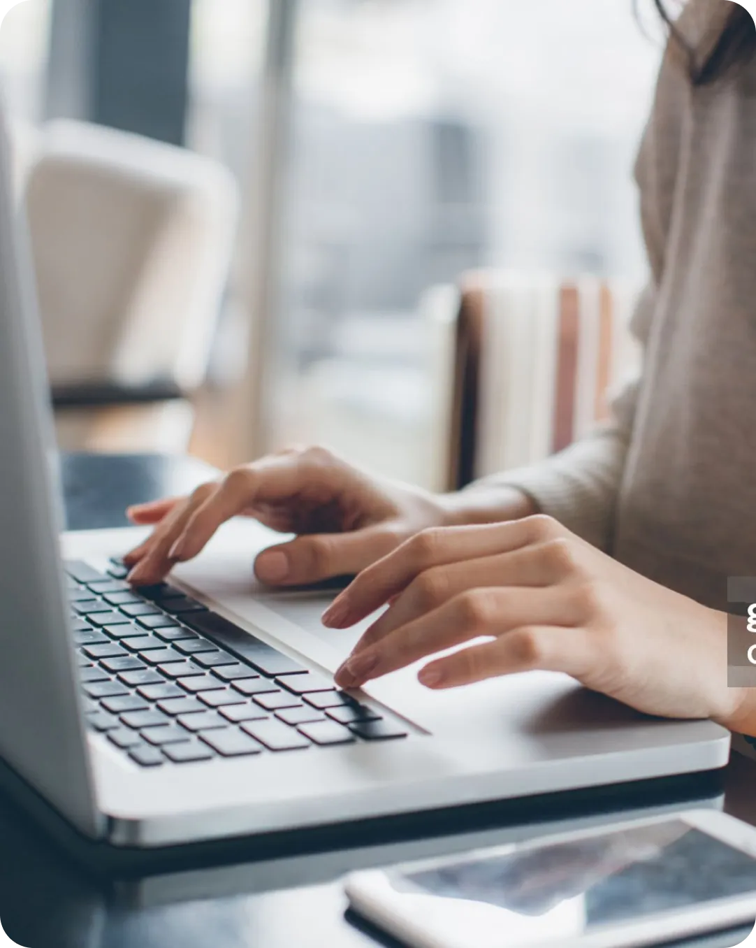 Close up of hands typing on a laptop that is protected by 2FA.