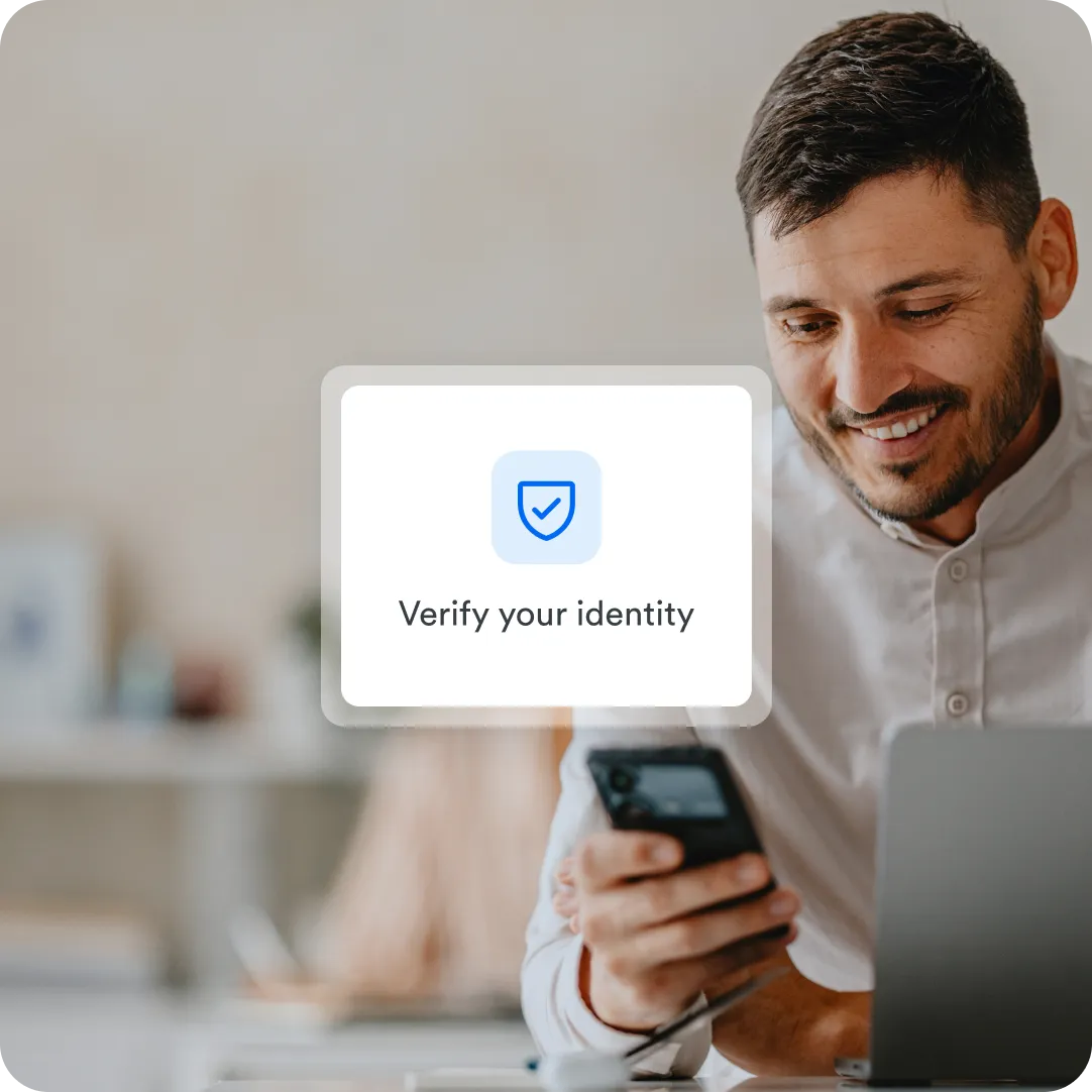User smiling down at their mobile device and a Duo Verify Your Identity prompt showing on their screen to use a token, passcode or mobile device to confirm identity.