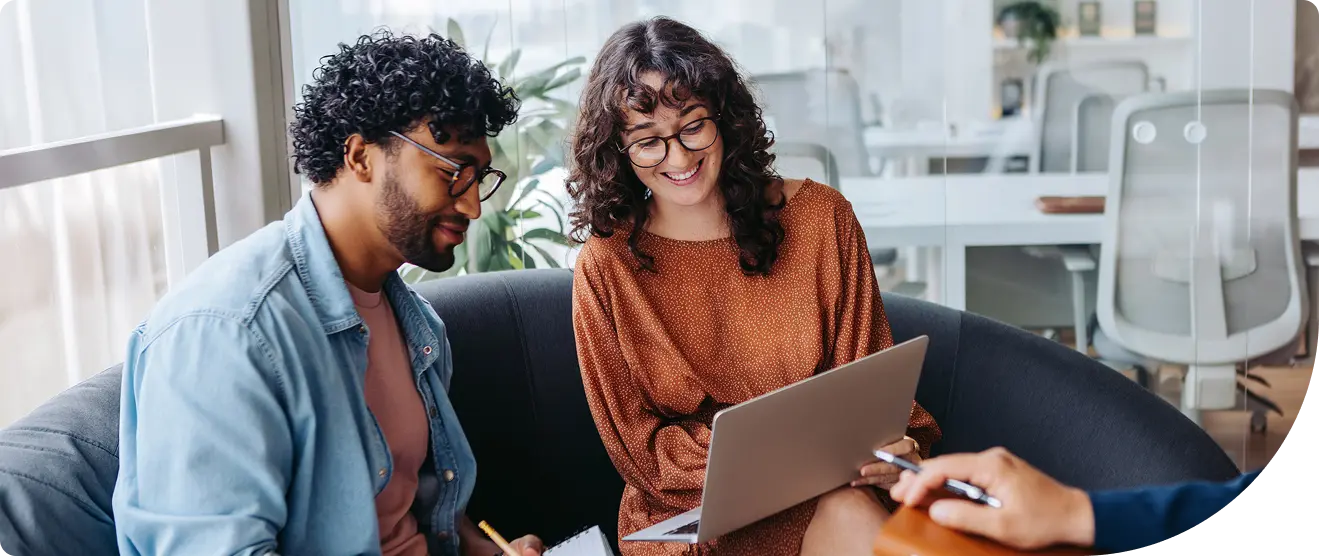 Four technology professionals collaborating at workstations displaying code in a modern office