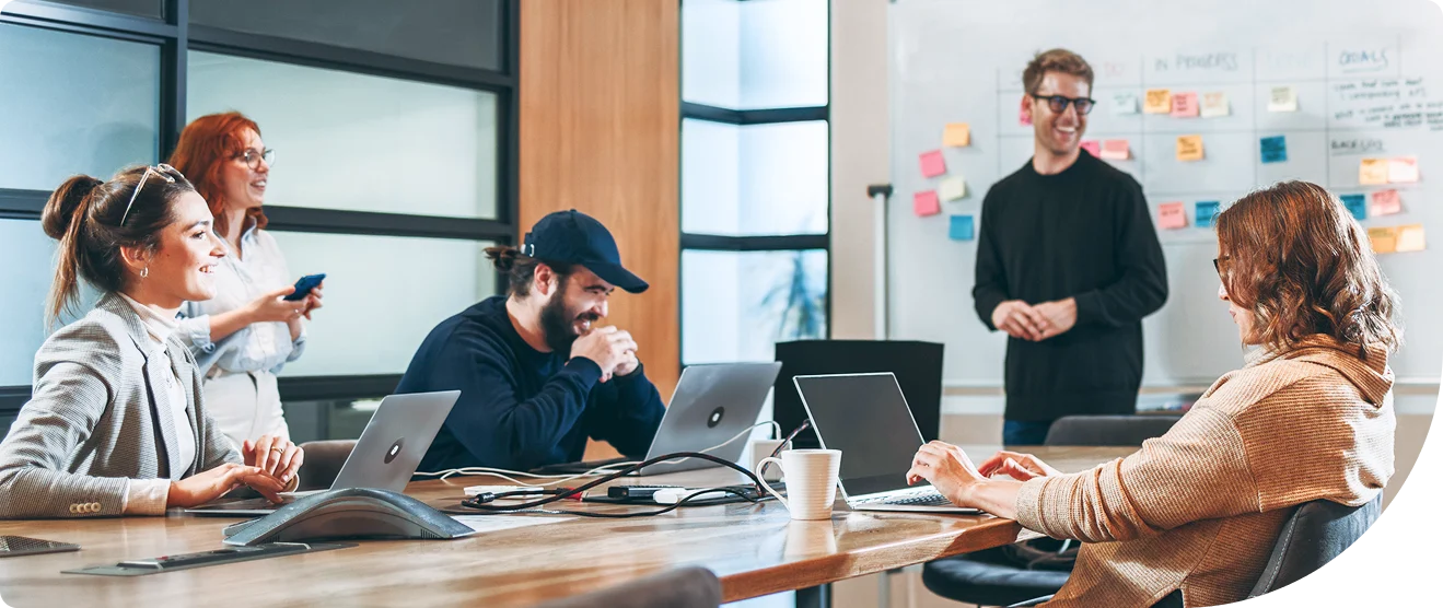 Team of professionals collaborating around a conference table with laptops during a cloud security planning session