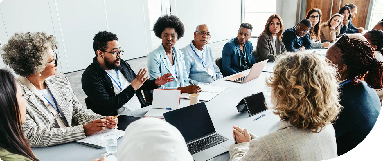 Security team collaborating around a conference table to discuss privileged access management strategy