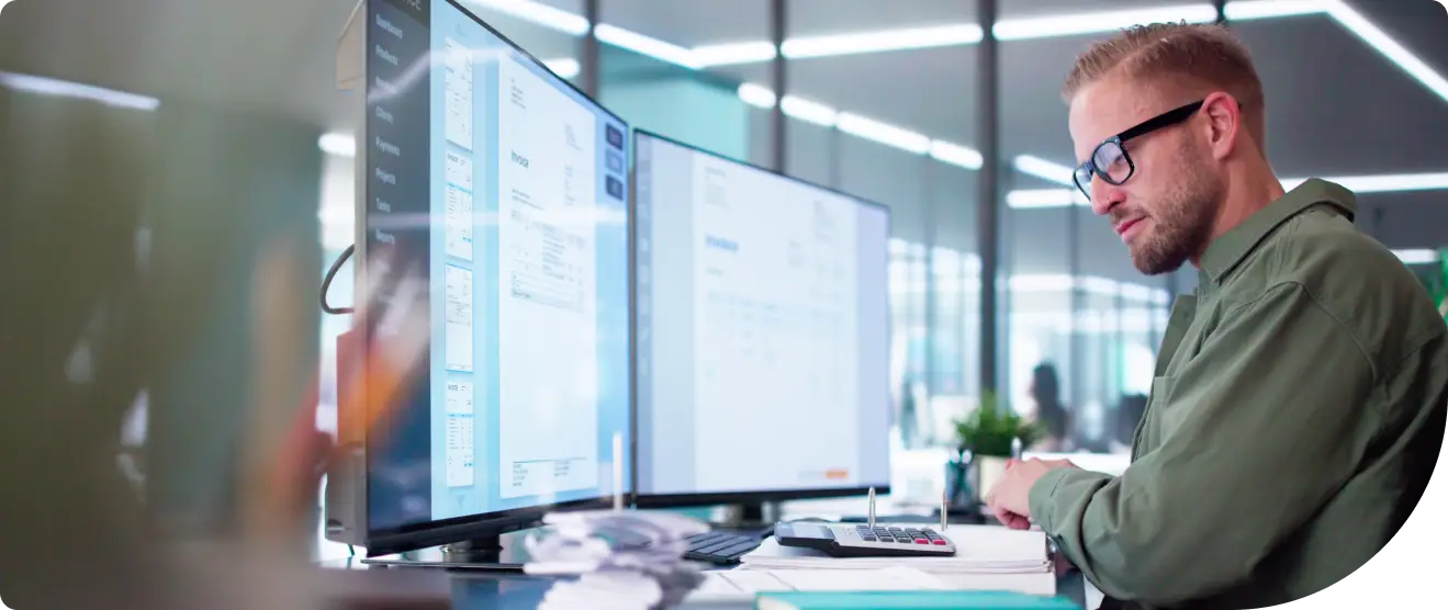 A worker in an office setting works securely on a trusted computer using IAM Compliant identity security from Duo.