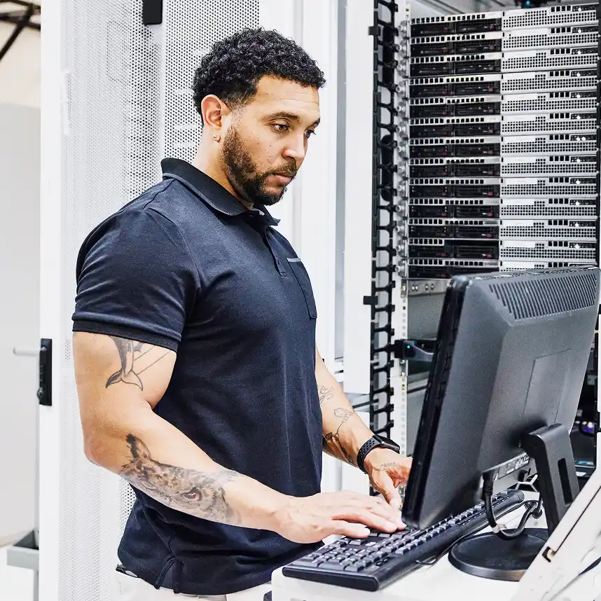 An IT manager is working in a data center to protect his workplace from identity-based threats.