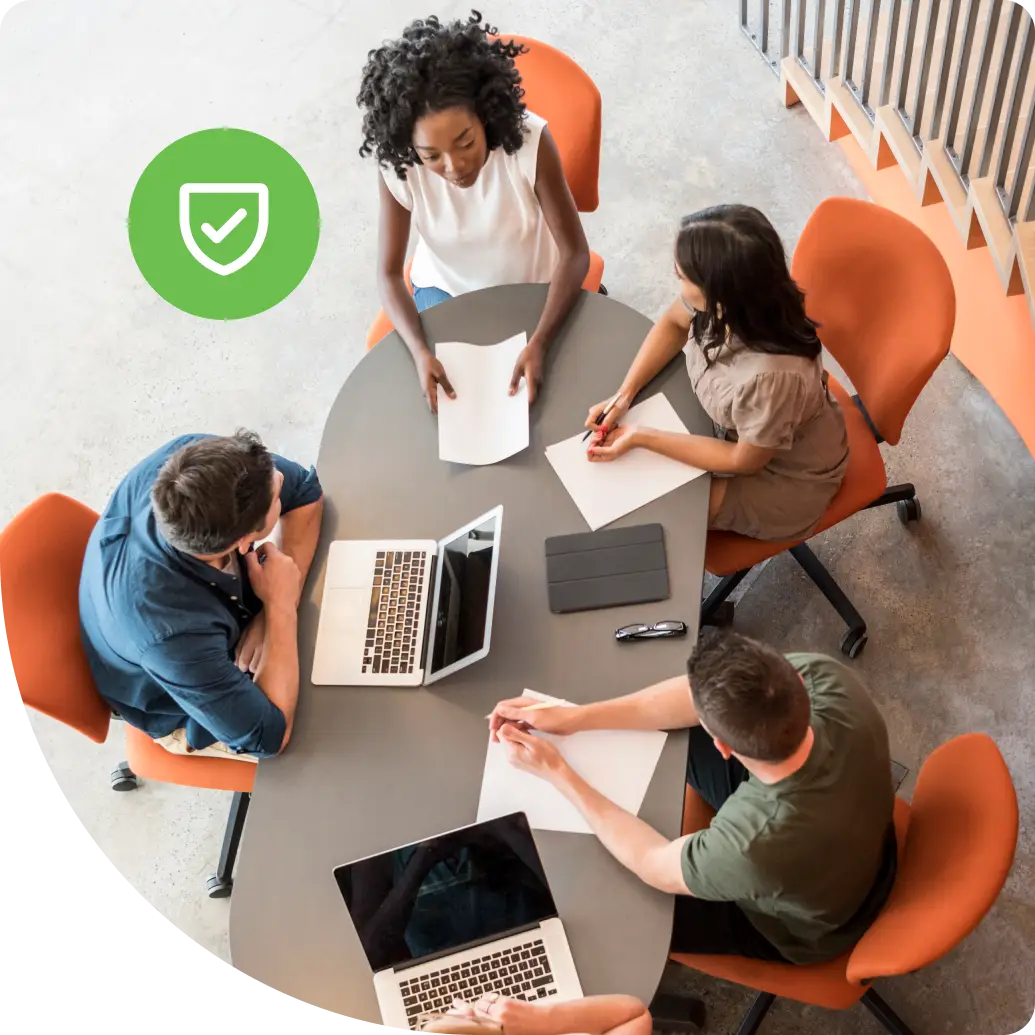 IT professionals meeting around a table with laptops, representing enterprise teams deploying AAA network security frameworks