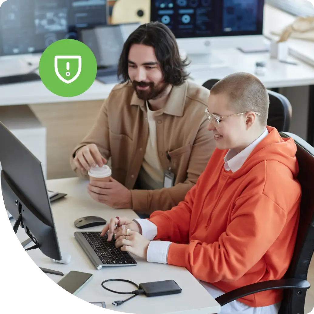 Two IT professionals reviewing identity security configurations at a workstation in a security operations setting