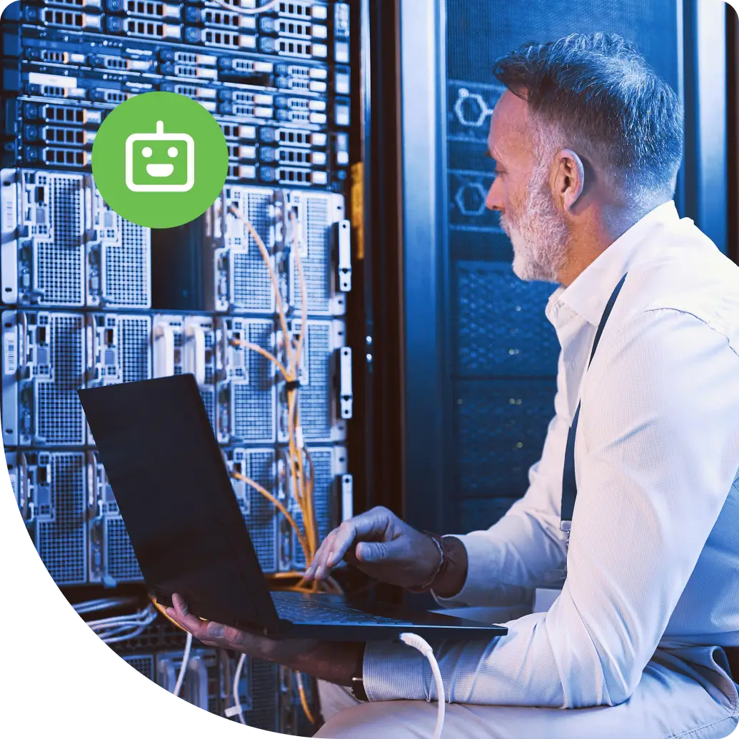 IT professional working on a laptop in a server room, managing non-human identity and machine access across enterprise infrastructure