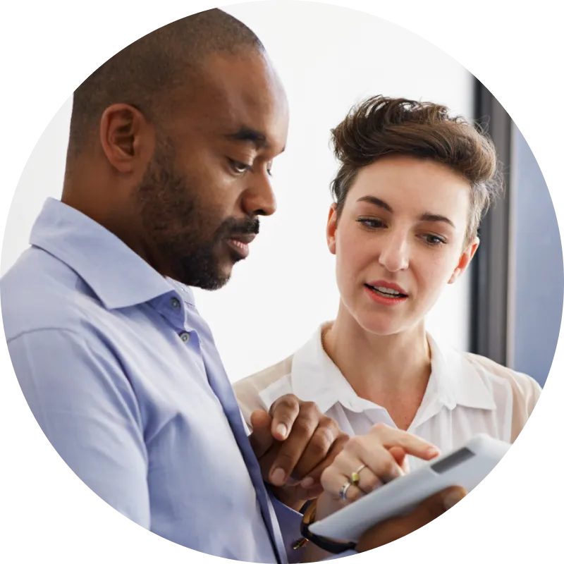 Two people reviewing something on a tablet.