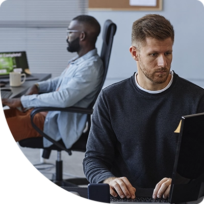 Two cybersecurity workers reviewing the TEI report from Duo after authenticating their trusted desktop devices