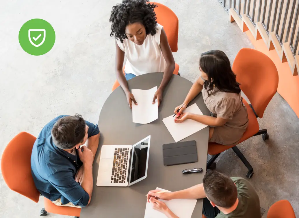 IT professionals meeting around a table with laptops, representing enterprise teams deploying AAA network security frameworks