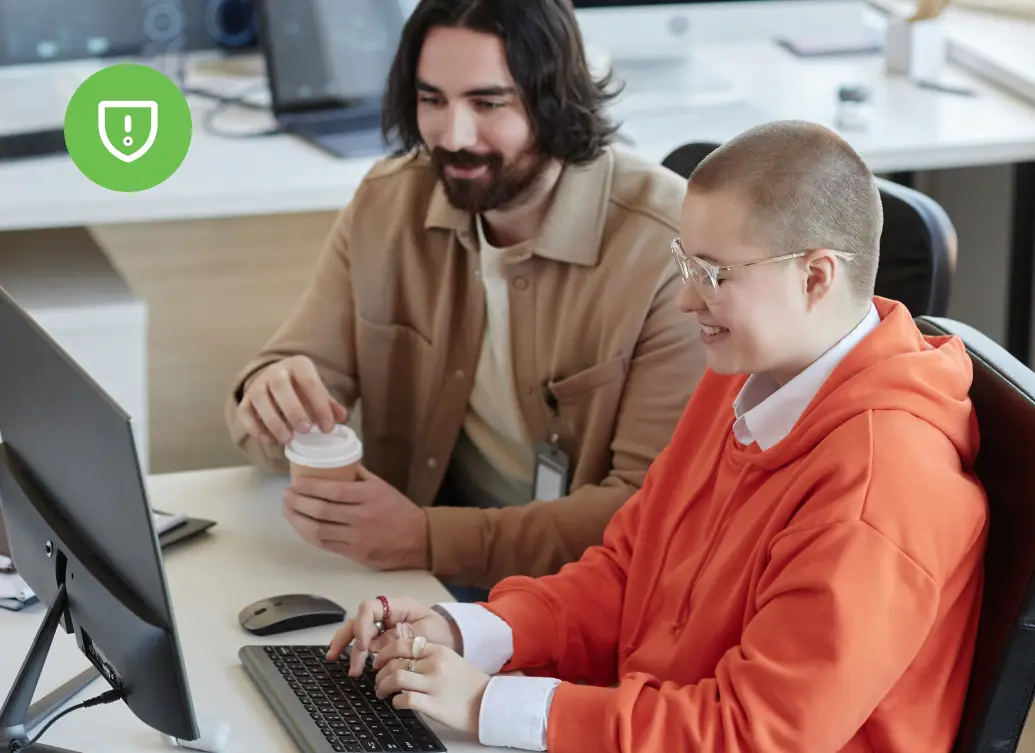 Two IT professionals reviewing identity security configurations at a workstation in a security operations setting