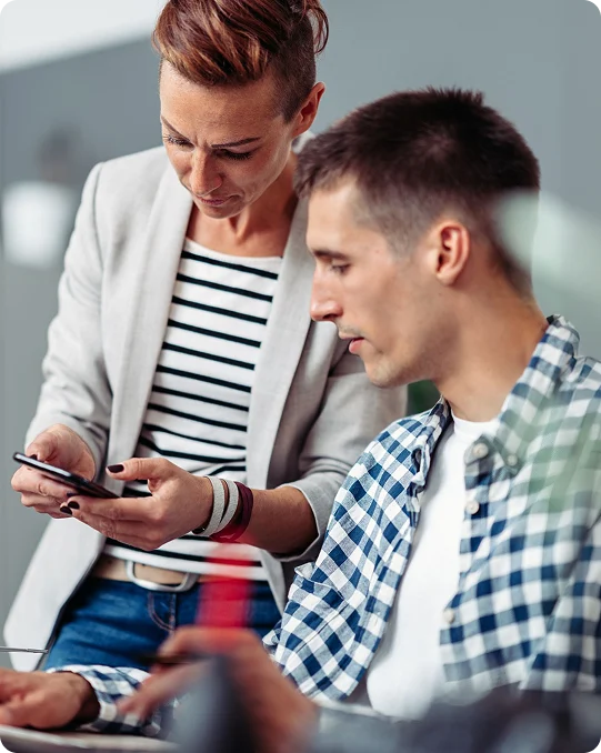 Two IT professionals reviewing SSH access authentication on a mobile device