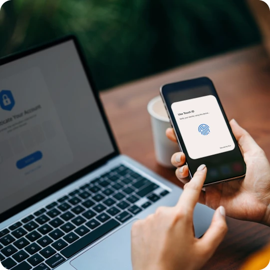User holding phone with Duo Push screen displayed, enabling secure login through MFA.